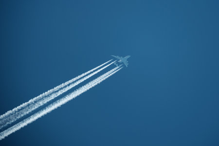 Airplane in the blue sky with white clouds on a sunny dayの写真素材