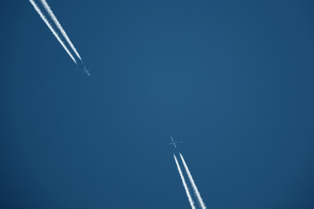 two planes in the sky, two airplane tracks in the blue sky, contrailsの写真素材