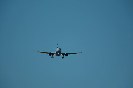 Airplane flying in the blue sky on a sunny summer day.