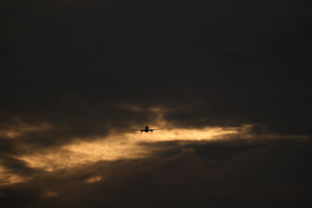 Silhouette of a passenger plane flying in the sunset sky.の写真素材