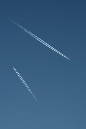 Airplane trail in the blue sky. Abstract background with copy space.の写真素材