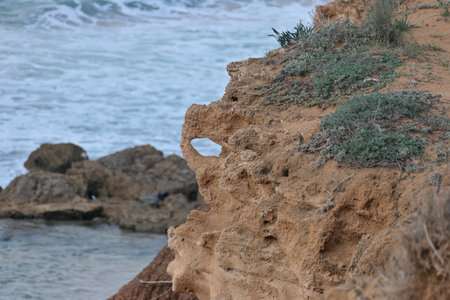 Rocky coast of the Mediterranean Sea in Israel. Hole in the rock. Landscape.
