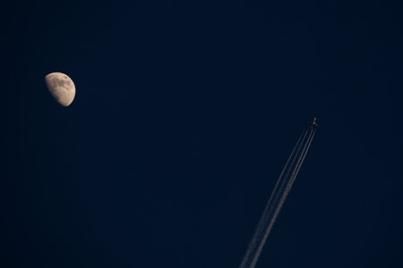 Moon and airplane in the sky at night. Sepia tone.の写真素材
