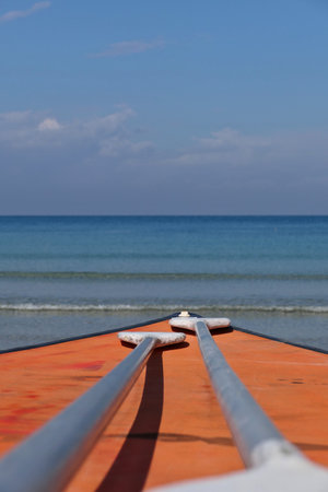 2 paddles resting on the paddleboard. Wooden boat and two paddles on the sea in the summer. Selective focus.の写真素材
