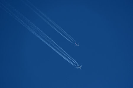 contrails in the blue sky with. Two airplanes in the blue sky.の写真素材