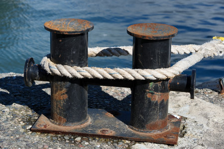 old mooring bollard with rope on the sea backgroundの写真素材