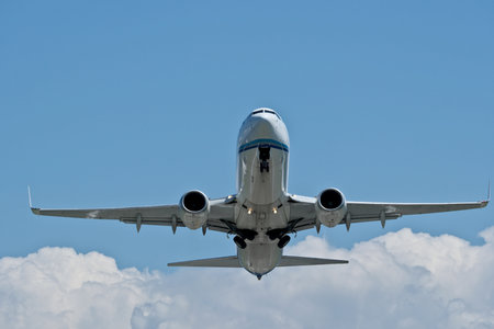 Airplane in the blue sky with white clouds, close-up
