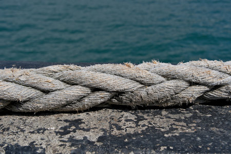 Rope on a mooring bollard with sea background