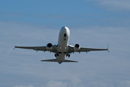 Airplane in the cloudy sky. The plane gaining altitude after takeoff from the airport.