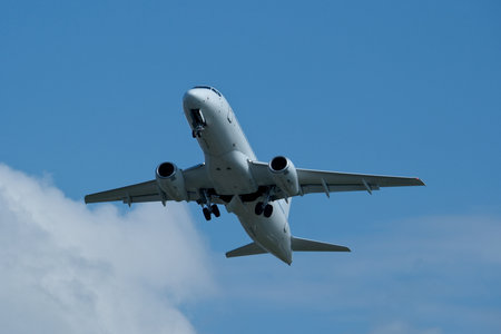 Airplane in the cloudy sky. The plane gaining altitude after takeoff from the airport.