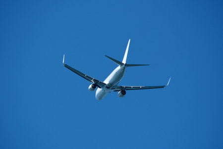 Airplane in the blue sky, close-up view of the plane. Aircraft soaring through the clear sky,...