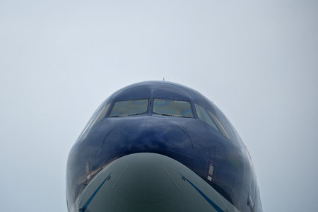 Close-Up of Passenger Jet Nose and Cockpit Windows. Airplane in the cloudy sky.の写真素材