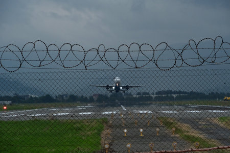 airplane with barbed wire on the background of the airport.の写真素材