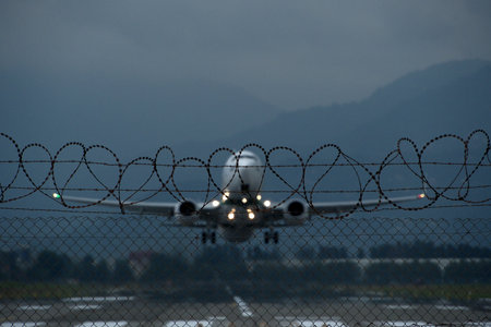 Airplane on the runway with barbed wire in the background.の写真素材