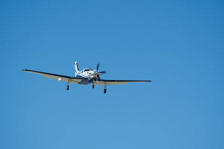 Small propeller airplane flying in the blue sky on a sunny day