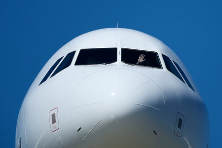 Clear Blue Sky and Aircraft Nose. Close-Up of Passenger Jet Nose and Cockpit Windows.
