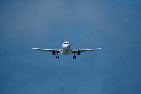 Airplane in the cloudy sky. An airplane flying near an airfield with its landing gear down