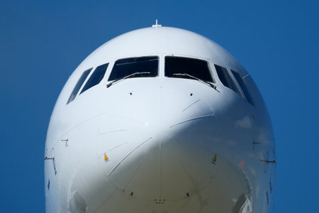 Clear Blue Sky and Aircraft Nose. Close-Up of Passenger Jet Nose and Cockpit Windows.の写真素材
