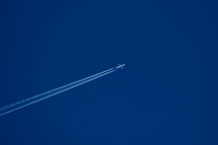 Airplane in the blue sky with white contrail. Airplane in the blue sky.の写真素材