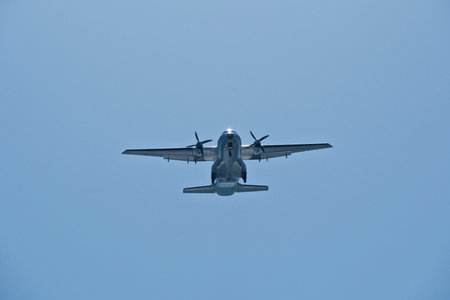 Two-engine airplane in the blue sky. Turboprop transport aircraft