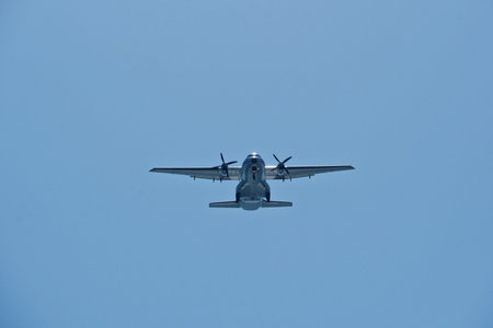 Two-engine airplane in the blue sky. Turboprop transport aircraft