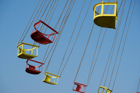 Colorful swing in the amusement park against the blue sky background.の写真素材