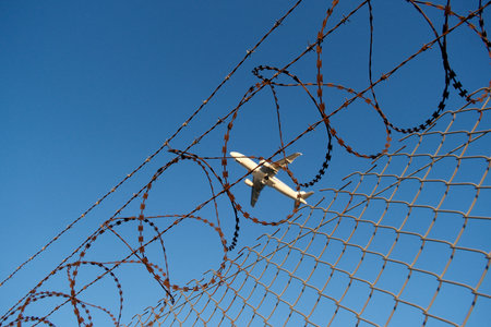 airplane in the blue sky with barbed wire, security conceptの写真素材