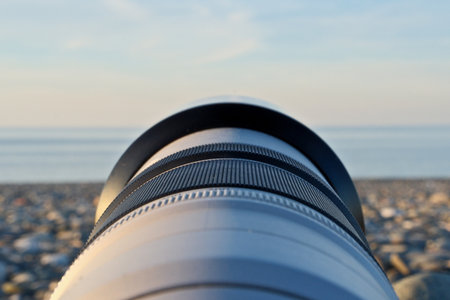 Photographer's Lens on Pebble Beach at Sunset. Camera Lens Aimed at the Open Sea.の写真素材