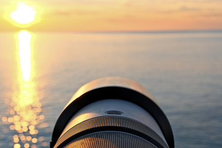 Photographer's Lens on Pebble Beach at Sunset. Camera Lens Aimed at the Open Sea.の写真素材