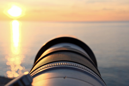 Photographer's Lens on Pebble Beach at Sunset. Camera Lens Aimed at the Open Sea.の写真素材