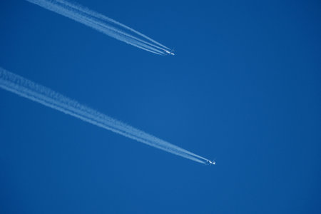Airplanes in the blue sky. Contrails from two planes flying side by sideの写真素材