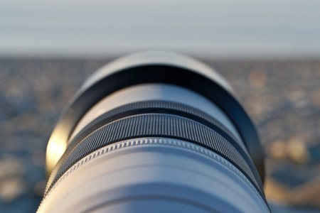 Photographer's Lens on Pebble Beach at Sunset. Camera Lens Aimed at the Open Sea.の写真素材