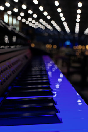 Piano keys with blue lights in a concert hall, shallow depth of fieldの写真素材