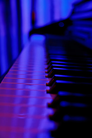 Piano keys close up in blue light with shallow depth of fieldの写真素材