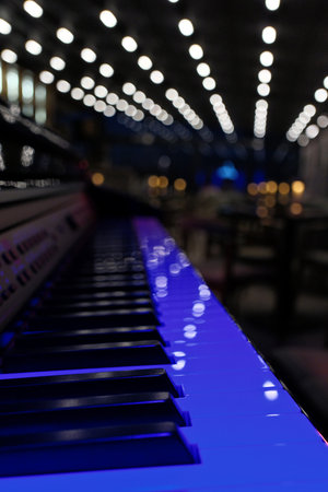 Piano keys in concert hall with lights and bokeh.の写真素材