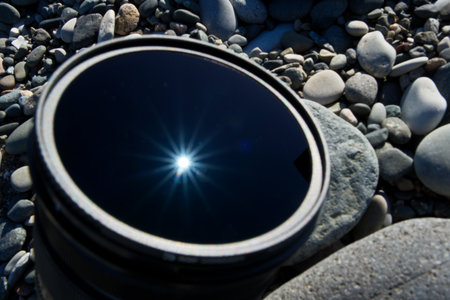 camera lens on the pebble beach, closeup of photoの写真素材