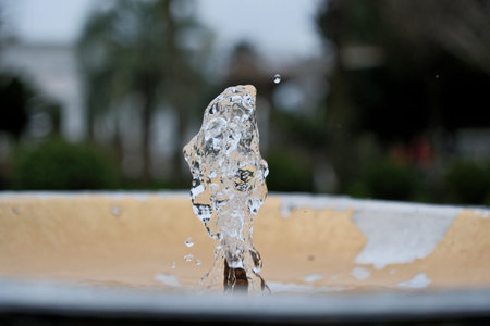 Water Splash from Drinking Fountain in Park â Blurred Background. Fresh Water Droplets from Resort Drinking Fountain, Shallow Depth of Fieldの写真素材