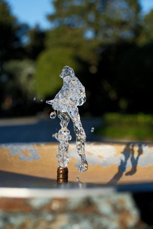 Water Splash from Drinking Fountain on a Sunny Day â€“ Blurred Background. Dynamic Splash in...