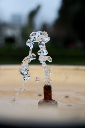 Water Splash from Drinking Fountain in Park â Blurred Background. Fresh Water Droplets from Resort Drinking Fountain, Shallow Depth of Fieldの写真素材