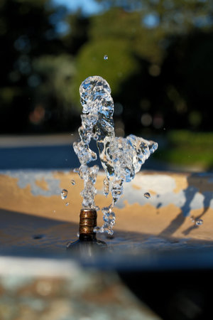 Water Splash from Drinking Fountain on a Sunny Day â€“ Blurred Background. Dynamic Splash in...
