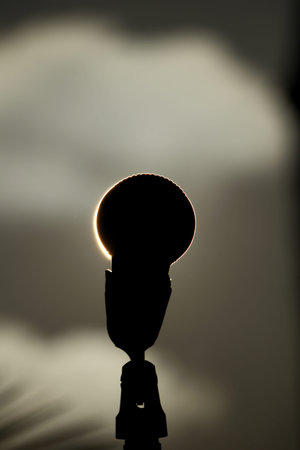 Microphone Silhouette Eclipsing the Sun at Golden Hour. Silhouette of Microphone Covering the Sun in...
