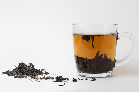 Glass of black tea on white background