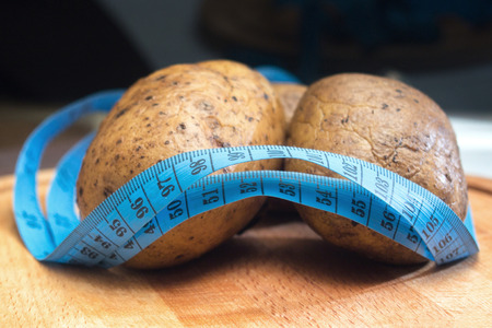 two potatoes wrapped with a tape to measure the waist, potato dietの写真素材