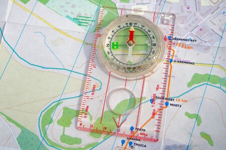travel sport compass lies on a map to determine azimuth movement