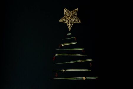 Hand made christmas tree on black background. Flat lay design. Copy Space. Minimalism.の写真素材