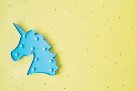 Blue unicorn with blue stars on yellow backdrop. Festive concept. Flat lay style.の写真素材