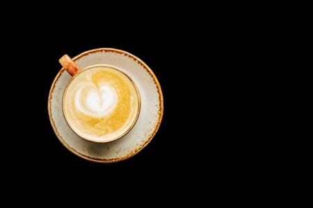 Coffee with milk in a cup. Cappuccino. On a black background isolated. Top view. Free copy space.の写真素材