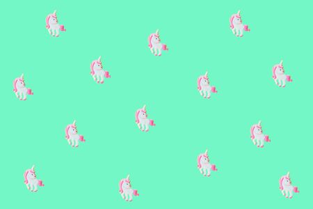 Pink unicorns on mint backdrop. Turquoise background for your text. Festive concept. Flat lay style.の写真素材