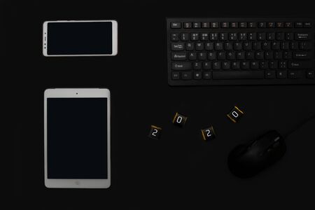 Fat lay with tablet, phone and chocolate 2020 on black bacgrond. Cyber Monday and Black Friday concept.の写真素材