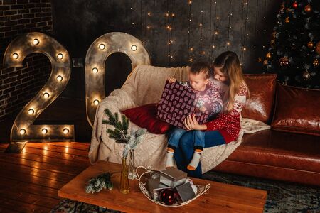 Mother and son open gift box and surprised in cozy room.の写真素材